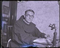 Father Superior Augustine seated at a desk at Hotel Alexandria, Los Angeles, 1925