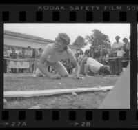 Man wearing a Jimmy Carter mask competing in "inaugural peanut push" contest in Long Beach, Calif., 1977