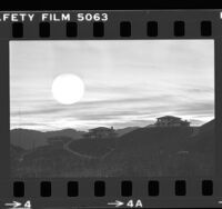 Sun setting behind housing developing on ridge near Mulholland Drive in Los Angeles, Calif., 1979