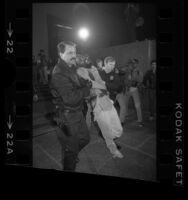 Homeless activist Ted Hayes being removed from Hall of Administration by policemen during Tent City protest in Los Angeles, Calif., 1985