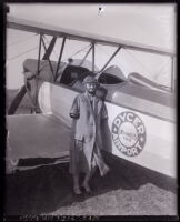 Armless pilot Josephine Callaghan standing in front biplane at Dycer airport, Los Angeles, 1929