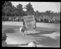 Two women carrying a banner announcing the start of the Tournament of Roses Parade, Pasadena, 1929