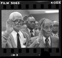 Two elderly Japanese American men taking United States citizenship oath in Los Angeles, Calif., 1980