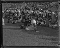 Stub Allison, assistant coach of the Golden Bears, talking to a player on the sideline during a match with the USC Trojans at the Coliseum, Los Angeles, 1934