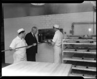 Cooks in the Los Angeles County General Hospital kitchen remove a pan from the oven, Los Angeles, [1934]