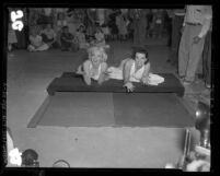 Marilyn Monroe and Jane Russell putting handprints in cement at Chinese Theater, Hollywood (Los Angeles), 1953