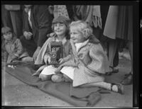 Two little girls with a camera seated on the Rose Parade route, Pasadena, 1930