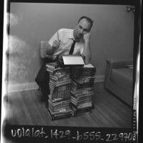 Writer Vernon Howard leaning against stacks of his self improvement books