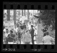 Pickets from the Peace Action Council protesting Hubert Humphrey visit, marching down sidewalk outside the Hollywood Palladium, 1968