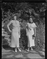 Mary Gene Hutters and Mrs. Wendell Hatteroth pose wearing stylish knitwear and hats at a party hosted by the Assistance Guild, Los Angeles, 1935