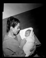 Dana Wynter holds her newborn son, Mark Bautzer, Los Angeles, 1960