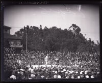 View of on open air boxing match with a crowd surrounding the ring, Wilmington (Los Angeles), 1925