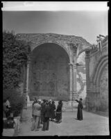 Father Arthur John Hutchinson leads a tour at Mission San Juan Capistrano, San Juan Capistrano, 1936