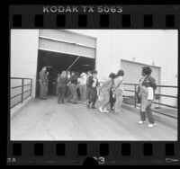 U.S. Immigration agents leading female illegal aliens from Lights of America Company factory in City of Industry, Calif., 1986