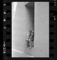 Male runaway sitting in alcove of building in Los Angeles, Calif., 1973