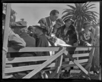 Man looks through a registration book at the annual Iowa Picnic in Lincoln Park, Los Angeles, 1936