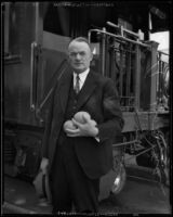 L. A. Downs, president of the Illinois Central Railroad, at railroad station wih citrus fruit, 1926-1938