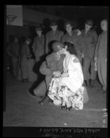 California National Guard signal corpsmen look on as corpsman kisses his wife good-bye, 1950