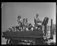 Four children sit atop a cart filled with pumpkins, Los Angeles, 1936