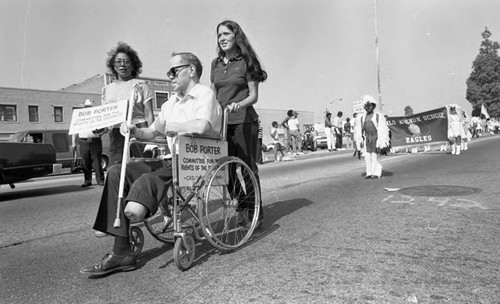 Bob Porter in a wheel chair participating in a parade, Los Angeles, 1982