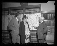 Astrologer Mrs. Colby Griffin examining horoscope with her attorney Robert A. Neeb and friend Ernest Wyher