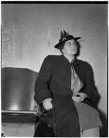 Veronica Greuzard wearing an overcoat and sitting in a chair, Los Angeles, 1937