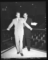 Reverend Billy Graham standing with Tiny Roebuck in ring at Hollywood Legion Stadium, Los Angeles, Calif., circa 1951