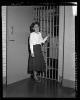 Dorothy Healey standing before jail cell in Los Angeles, Calif., 1949