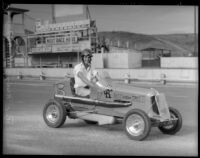 Race car driver Rex Mays poses in a "midget" car at the Legion Ascot speedway, Los Angeles, 1935