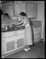 Jean Wilson fills a pot with water at a kitchen sink, Los Angeles, 1930s