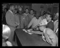 Douglas F. Shaw accepting badges of resigning reserve police officers at Newton Street Station after death of James Woodson Henry, Los Angeles, Calif., 1950
