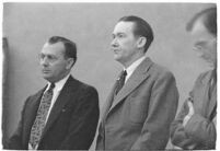 Murder suspect Robert S. James standing between two unidentified men in court, Los Angeles, 1936