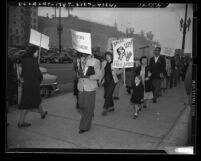 Demonstrators picketing Federal Building, one sign reading "Pay Checks Not Loyalty Checks" in protest over investigation of Communism in Los Angeles, Calif., 1948