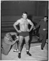 Wrestler and football player Bronko Nagurski having his thigh measured before a wrestling match at Wrigley Field, Los Angeles, August 11, 1937
