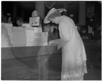 Woman looking at a stack of Maycrest fancy back playing cards during the semiannual Dollar Day sale in downtown Los Angeles, February 17, 1940