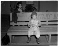 Young boy sits on a bench in Chinatown, Los Angeles, 1930s