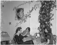 Female impersonator Johnnie David and two unidentified women drinking at a table, Hollywood, circa 1937