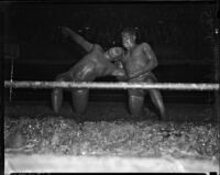 Sandor Szabo puts a hold on Prince Bhu Pinder during a mud wrestling match at Olympic Auditorium, Los Angeles, October 20, 1937