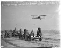 Soldiers aim anti-aircraft gun at Douglas plane during a military show for National Defense Week, Los Angeles, 1940