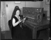 Mrs. Elaine Anderson Dudley poses next to a switchboard, Los Angeles, 1934