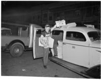 Newspaper vendor sells issue with the frontpage headline "Roosevelt Landslide!" on election night, Los Angeles, 1936