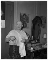 Euclide Allard, 66, holding a piece of twine and a towel used by a burglar to tie up Allard in his hotel room, Los Angeles, February 16, 1940