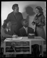 Four youths manning desk during the American Brotherhood Week in 1946