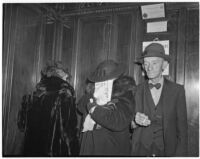 Winifred Westover Hart using a magazine to hide her face from photographers during the George K. Dazey murder trial, where she was a witness, Los Angeles, 1940