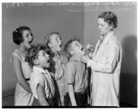 Nora Olsen, school nurse, inspecting students, Los Angeles, 1936