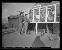 Soldiers Rene Bourg and Ralph Blanchard looking at movie posters in Fort Ord, Calif., 1940