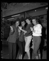 Four teenage girls on Easter vacation playing in game area of Newport Beach Pier, Calif., 1954