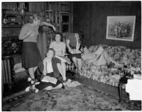 Group of young women read books and write together at their USC sorority house, Los Angeles, 1940