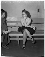 Merle McClurg sitting on a bench talking to an unidentified man, Los Angeles