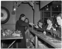 Charlie Chan, fortune teller, speaks to customers in Chinatown, Los Angeles, 1930s